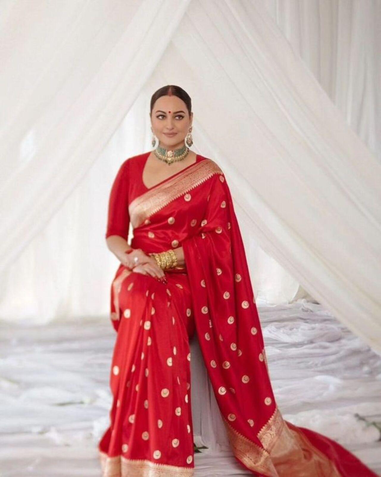 Sonakshi Sinha looked radiant for her reception in a red silk brocade saree with motifs of a crescent moon in gold. The traditional wear was complemented with a contrasting jewellery set featuring a choker and chandbalis. Her signature winged eyeliner, kohl-laden eyes, red sindoor and bindi completed her beautiful bridal look.